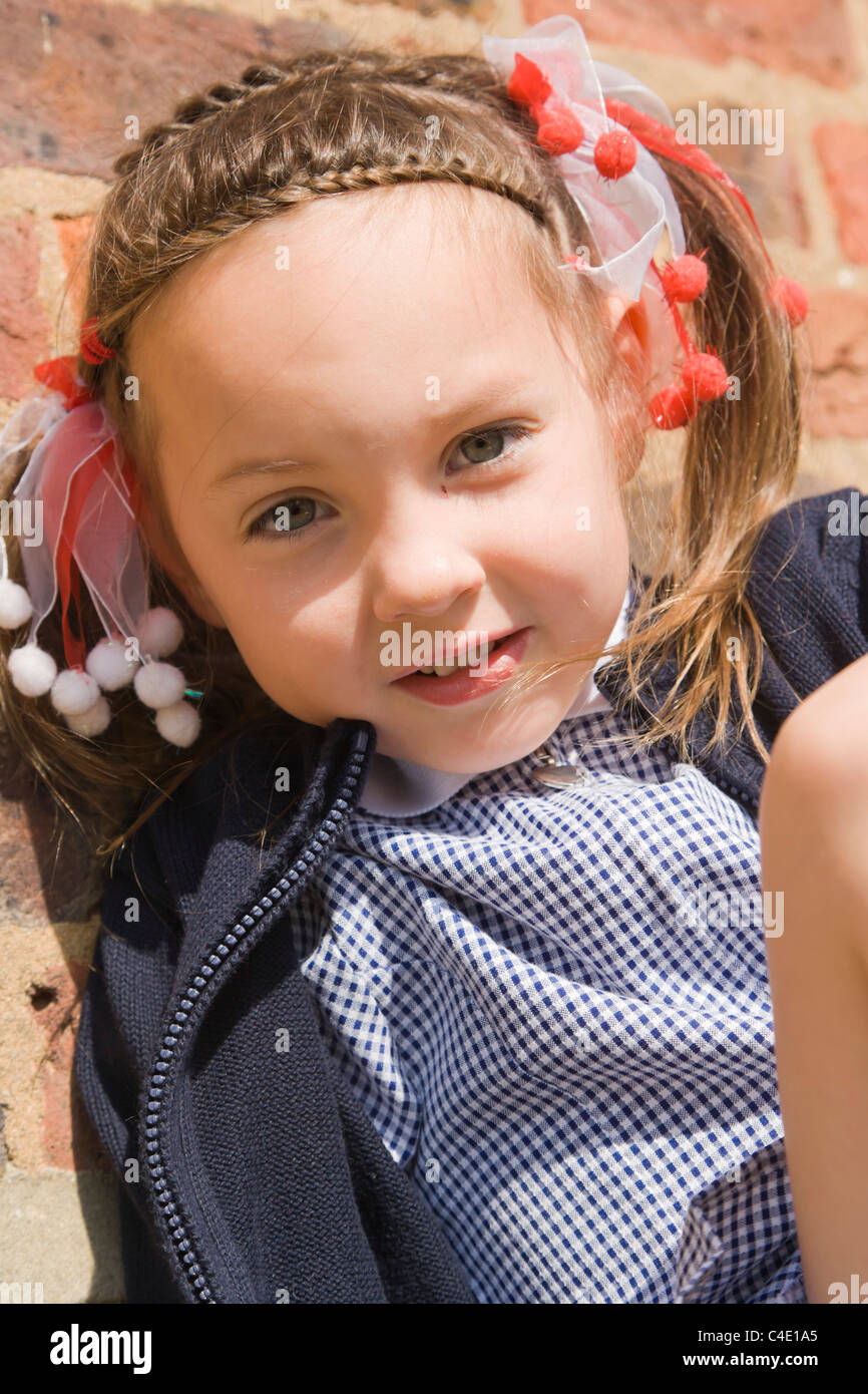 4 years old schoolgirl in gingham dress, summer school uniform Stock Photo