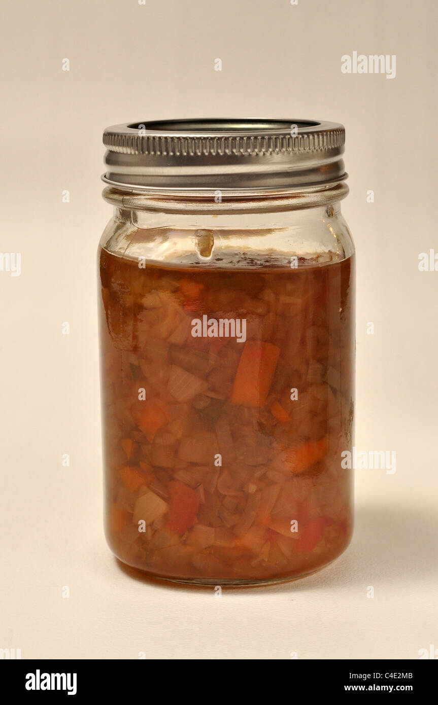 A jar of home made relish sits on a white background Stock Photo