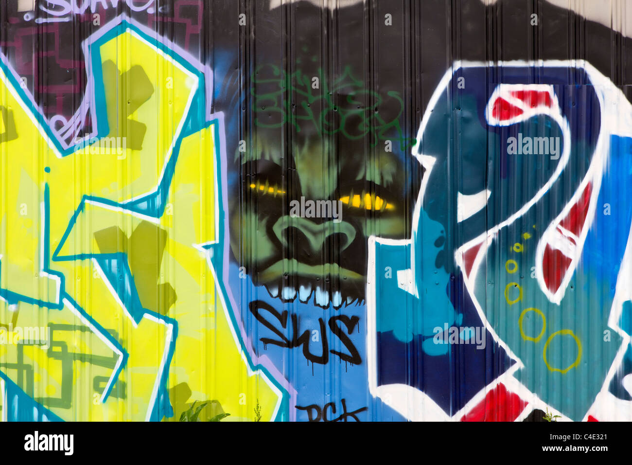 A Green Monster peers through two graffiti scribblings Stock Photo