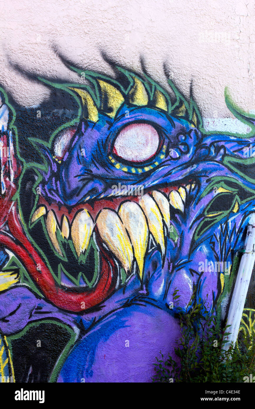 A purple graffiti monster painted on a textured wall Stock Photo Alamy