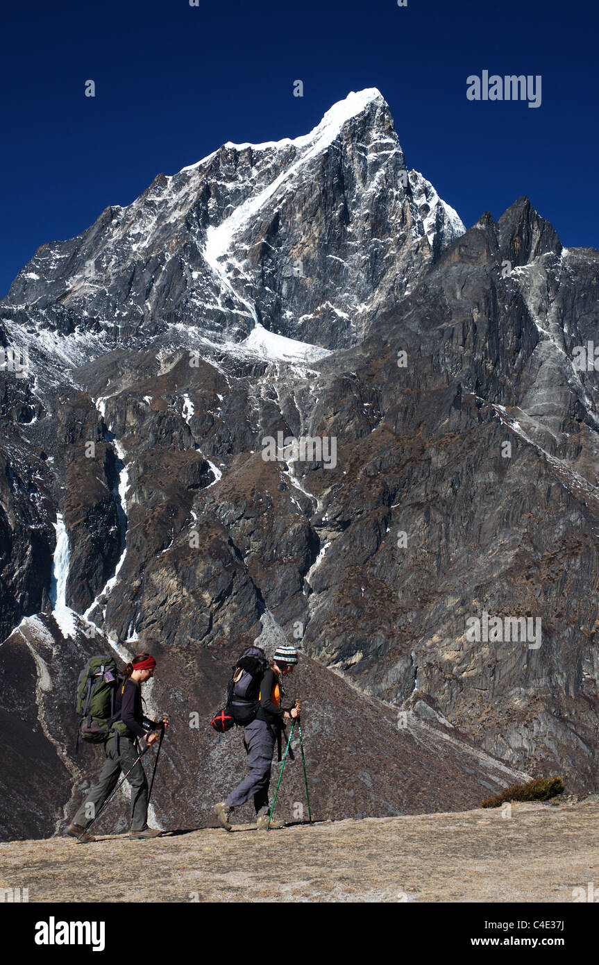 Two female trekkers pass in front of Taboche peak in Nepal Stock Photo