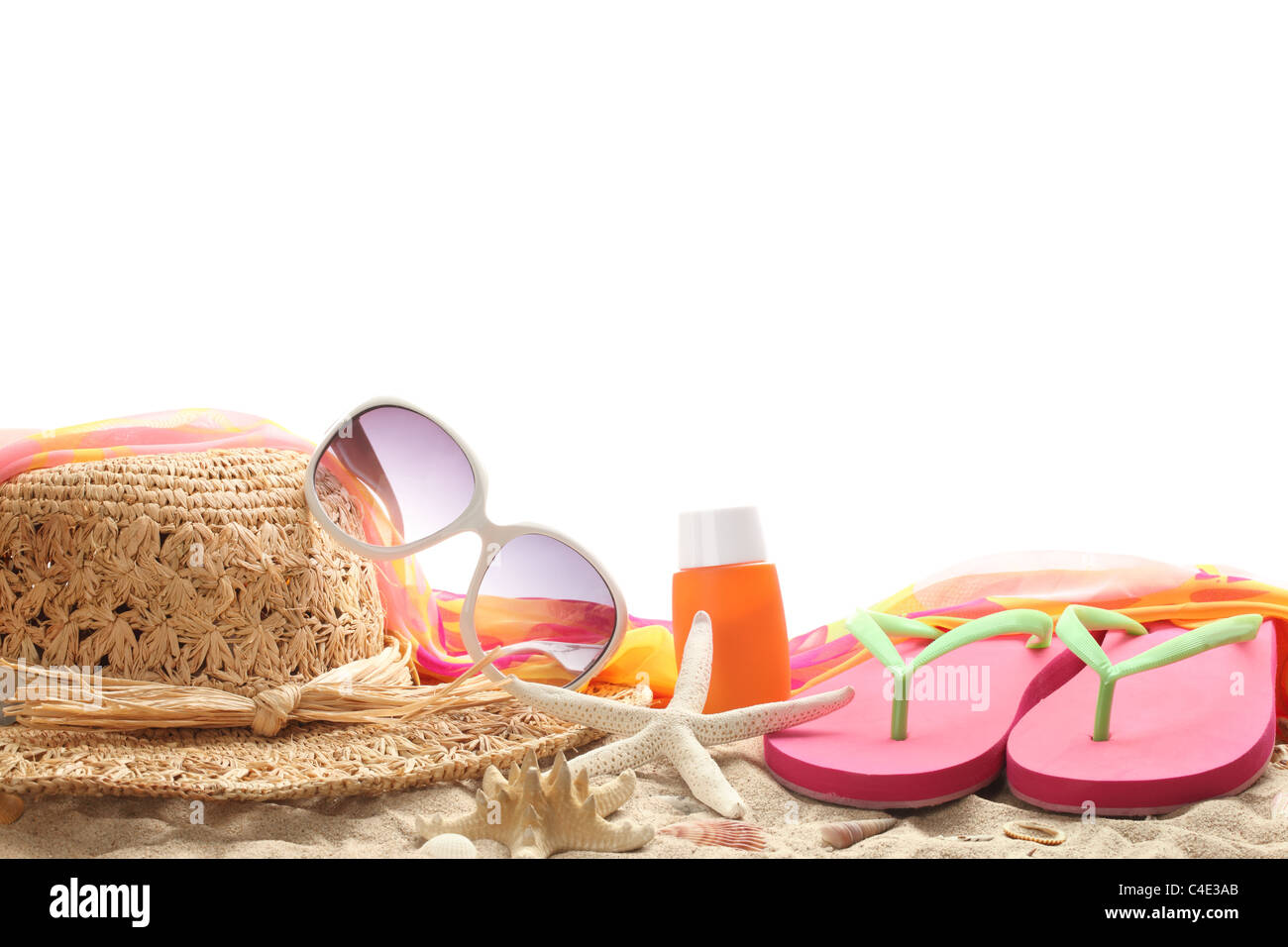 Beach accessories with straw hat,sun glasses,shawl and flip flops on sand. Stock Photo