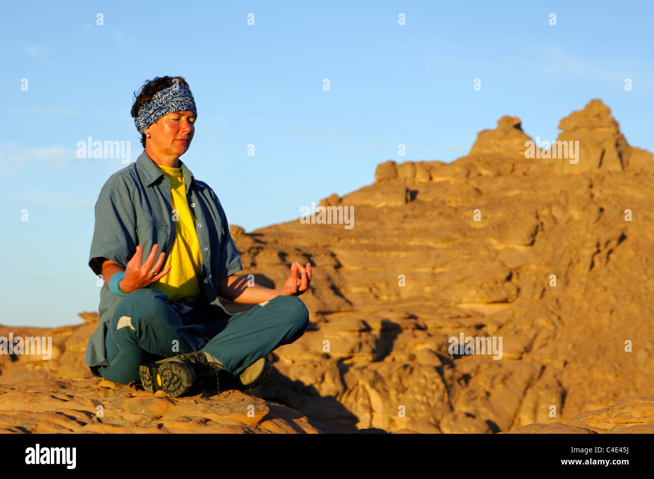Young woman focussing on yoga excercises in a Buddha lotus seat position in a remote mountainous region Stock Photo