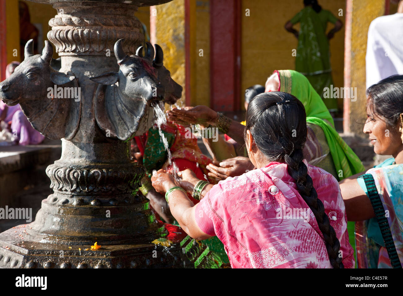 Indian women taking water from the sacred fountain. Ram Kund. Godavari river. Nasik. India Stock Photo