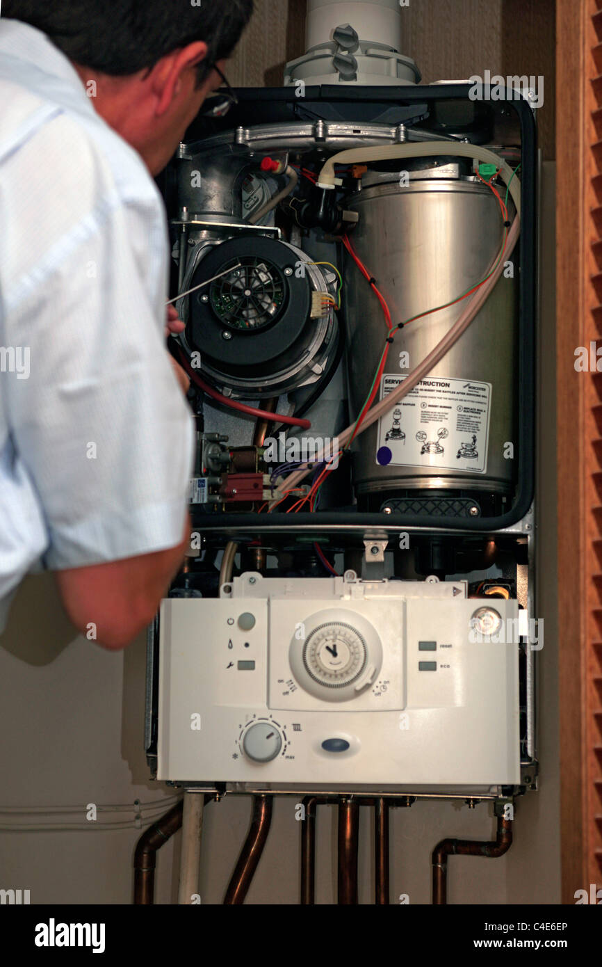 Gas central Heating engineer services a household boiler unit and tests