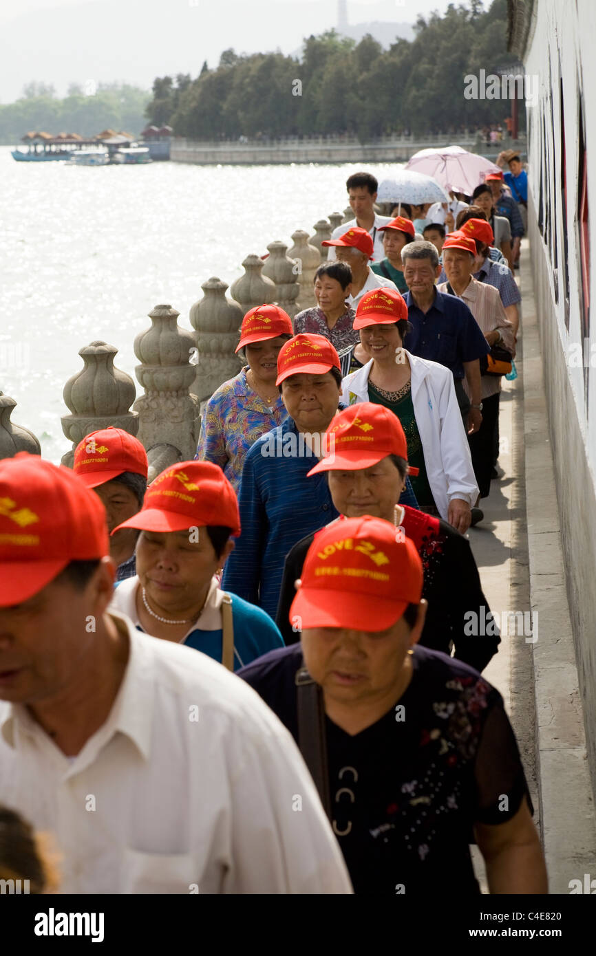 Chinese tourists with red baseball caps sun hat walk beside Lake Kunming The Summer Palace in Beijing China Stock Photo Alamy
