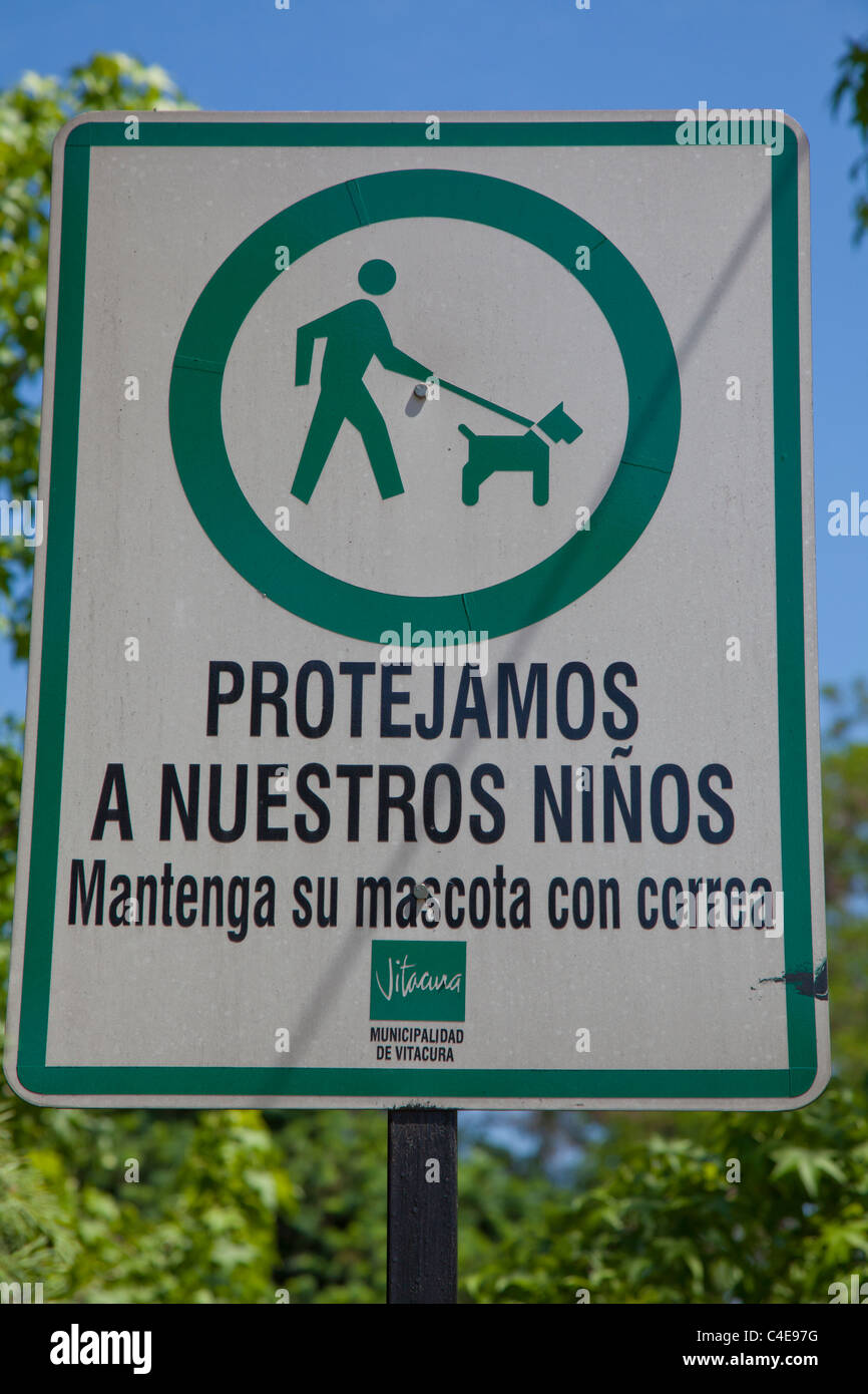 Sign in park in Vitacura, Santiago, Chile, telling park users to keep their dogs on a lead to protect the local children Stock Photo