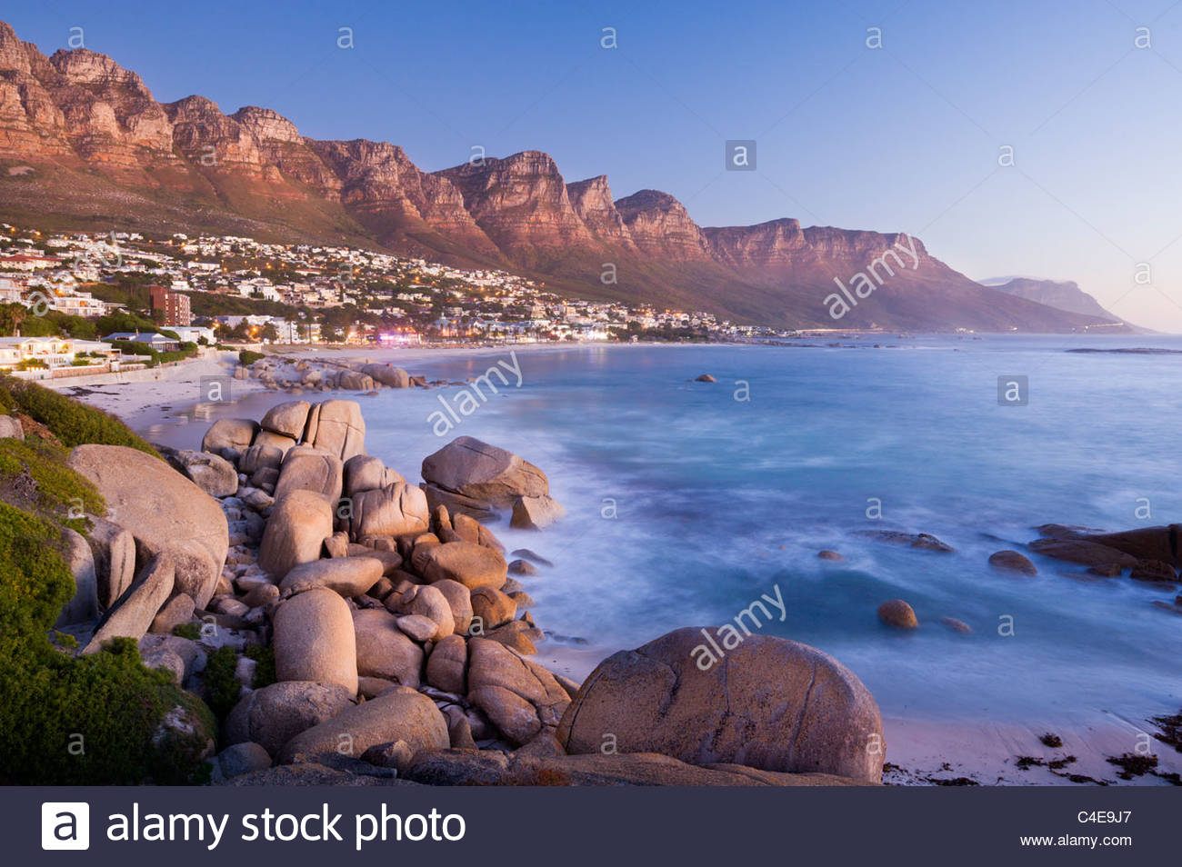 The Twelve Apostles loom over Camps Bay, near Cape Town, South Africa. Stock Photo