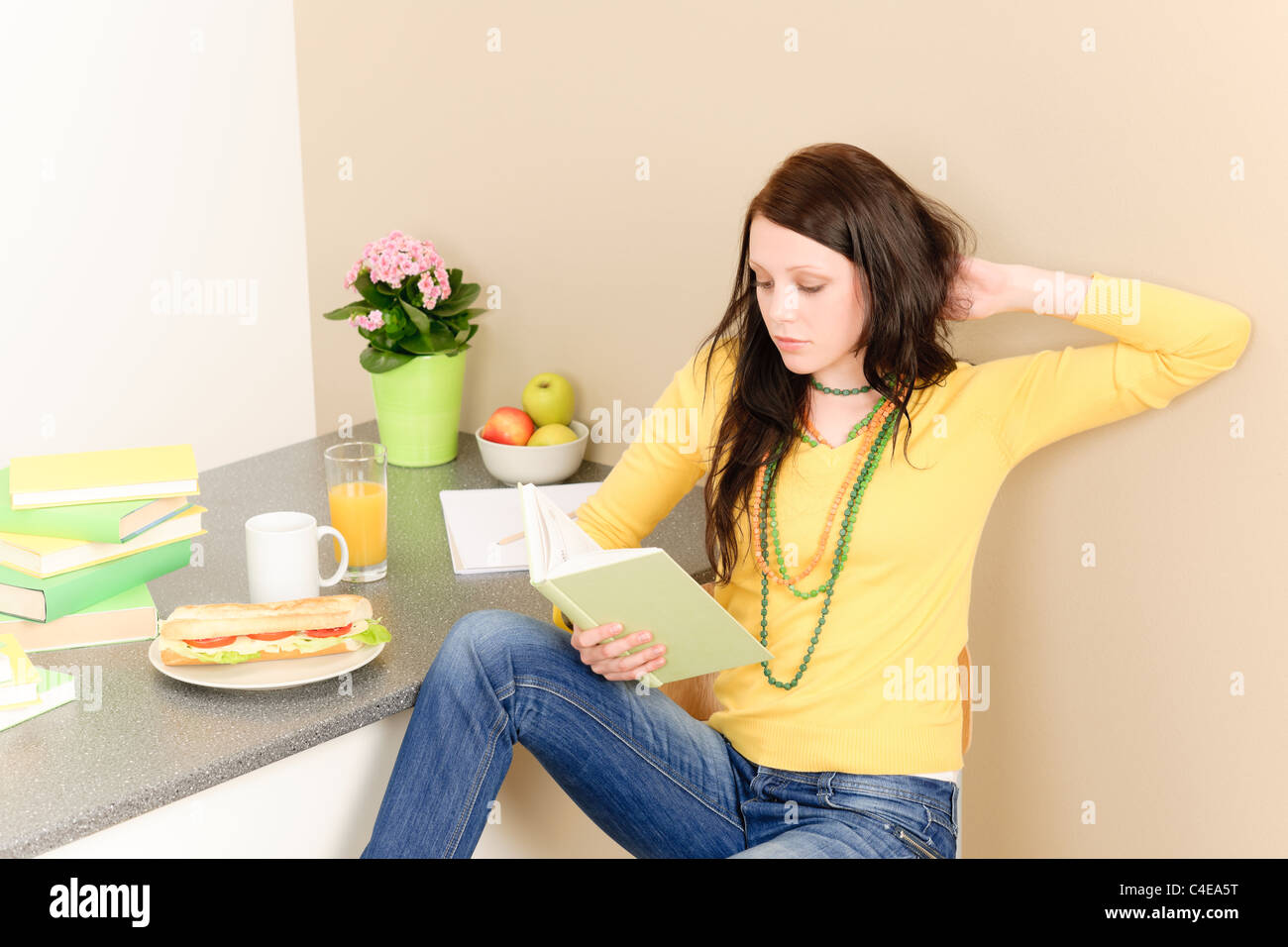 Young student girl reading book in student apartment Stock Photo - Alamy