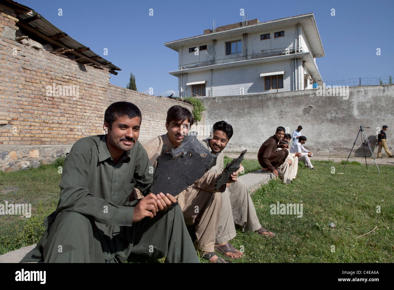 house in Abbottabad, pakistan where bin laden was killed. the boys holding pieces of the US crashed helicopter Stock Photo