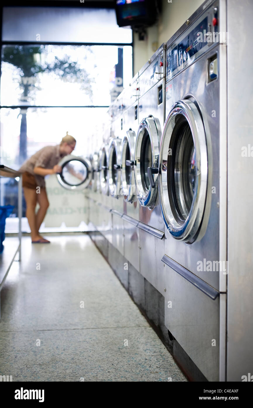Young woman in laundromat Stock Photo