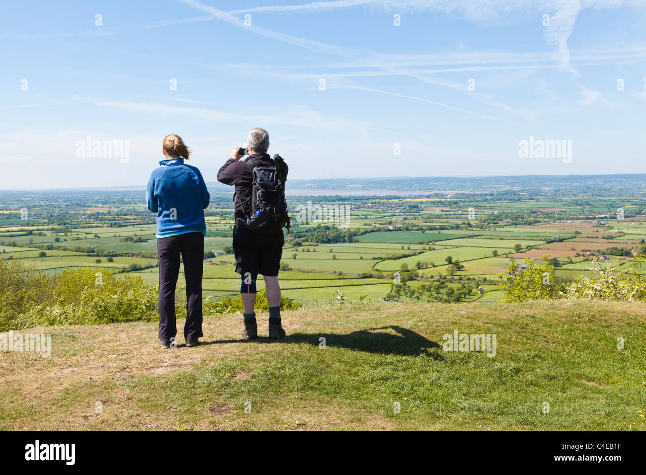 Walkers enjoying the view across the Severn Vale to the Forest of Dean from the Cotswold Way on Haresfield Hill, Gloucestershire UK Stock Photo