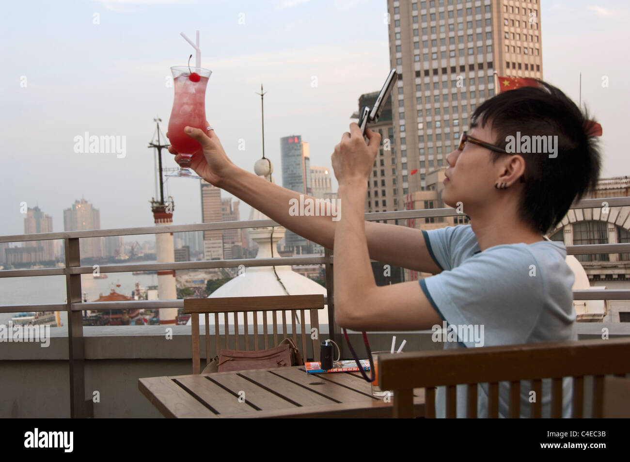 Man taking photograps of drink in  the riverfront. Shanghai China Stock Photo