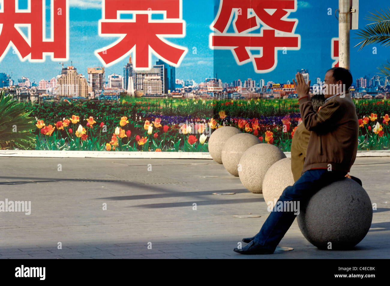 People walking in front of billboards erected around a building site, downtown Shanghai near the Bund, China. Stock Photo