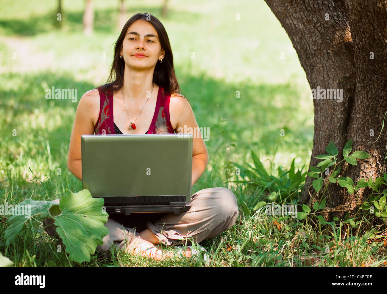Happy young woman using her laptop outdoors Stock Photo - Alamy