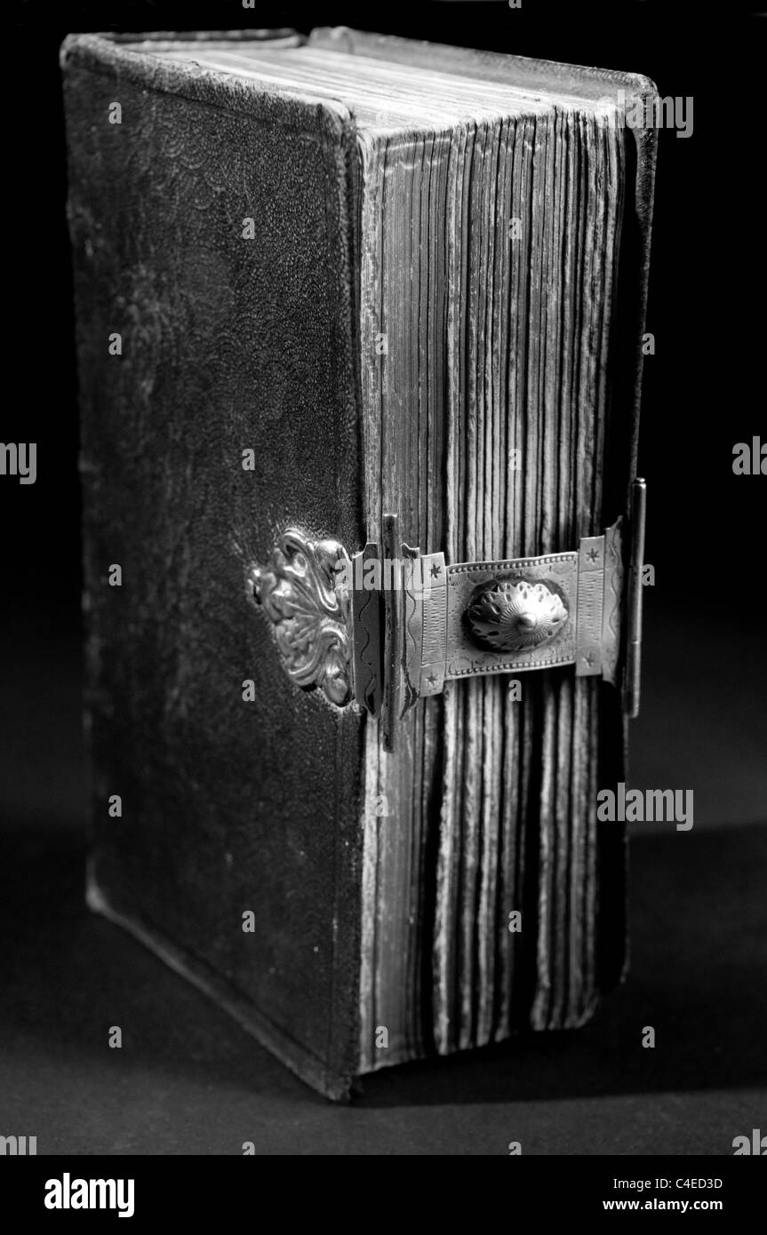 Nice old bible with an old lock on a black background. In black & white. Stock Photo