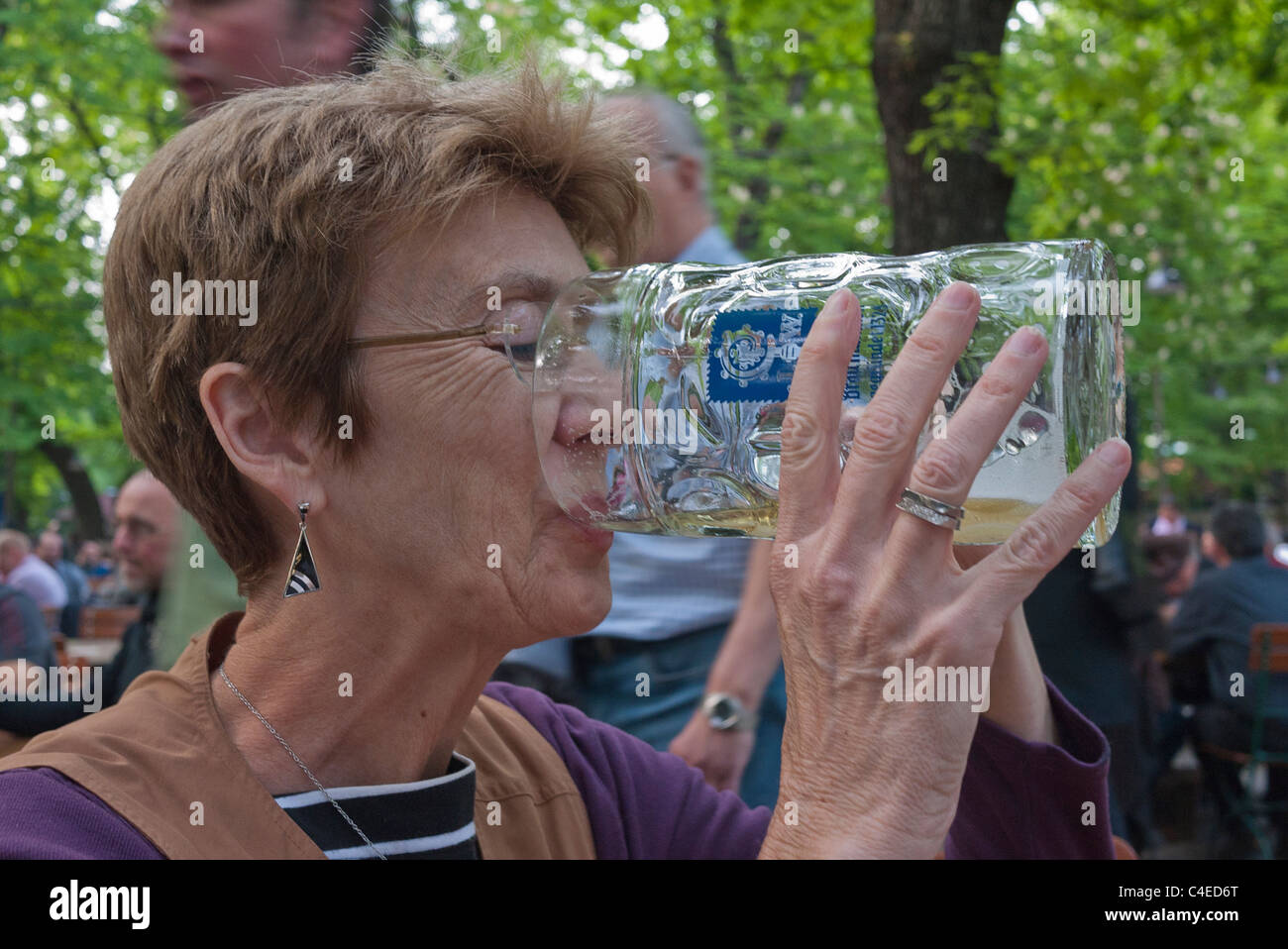 A female tourist drinks from a very large beer stein at the Augustiner-Keller beer garden in Munich, Germany. Stock Photo