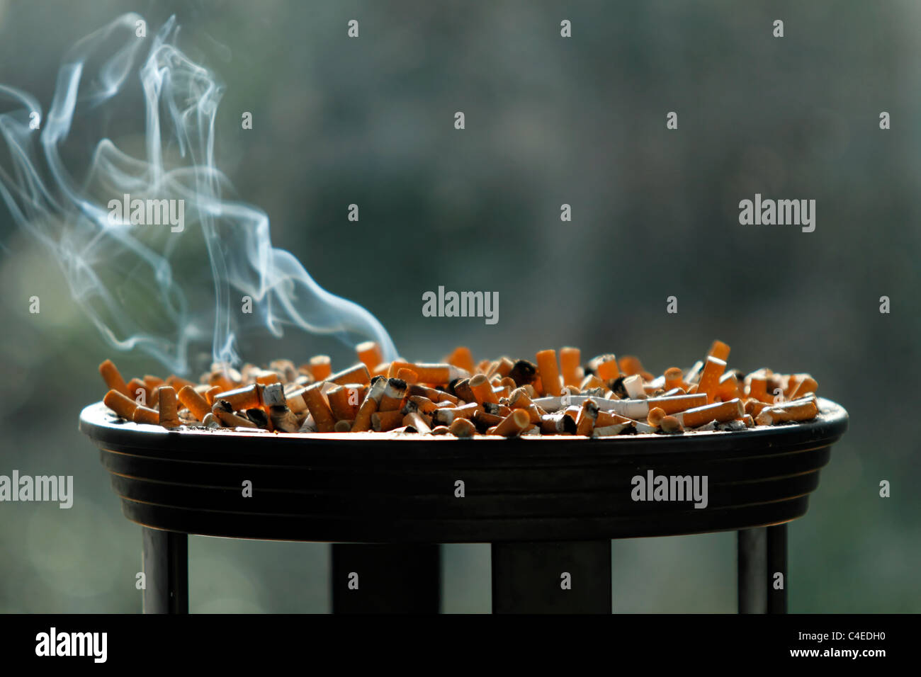 Large ashtray full of smouldering cigarette butts Stock Photo Alamy