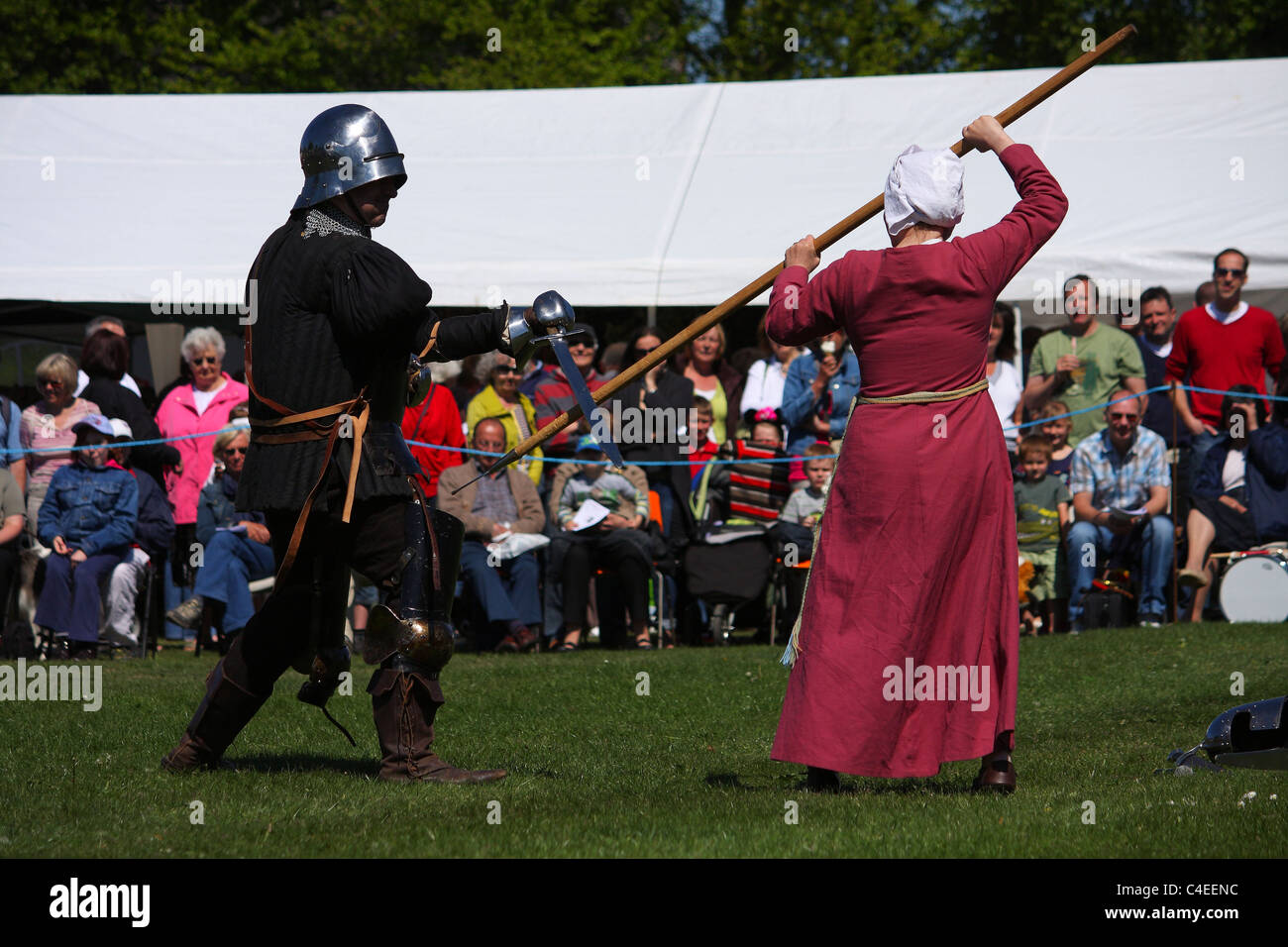 A battle re-enactment with a male knight and a female defending herself. Stock Photo
