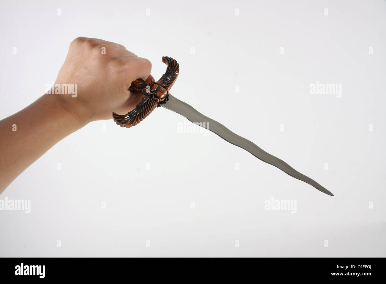 Holding a lock knife and demonstrating its use as a lethal weapon. A knife has a sharp blade usually made of stainless steel. Stock Photo