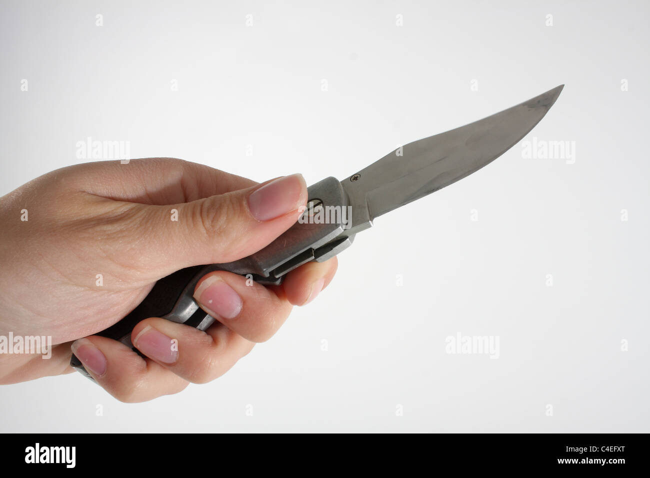 Holding a lock knife and demonstrating its use as a lethal weapon. A