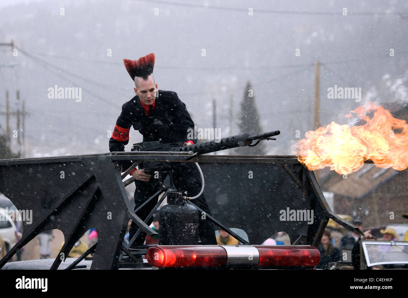 A man dressed as a punk rocker stands atop a hearse with a lit flame  thrower at the Frozen Dead Guy Festival Stock Photo - Alamy