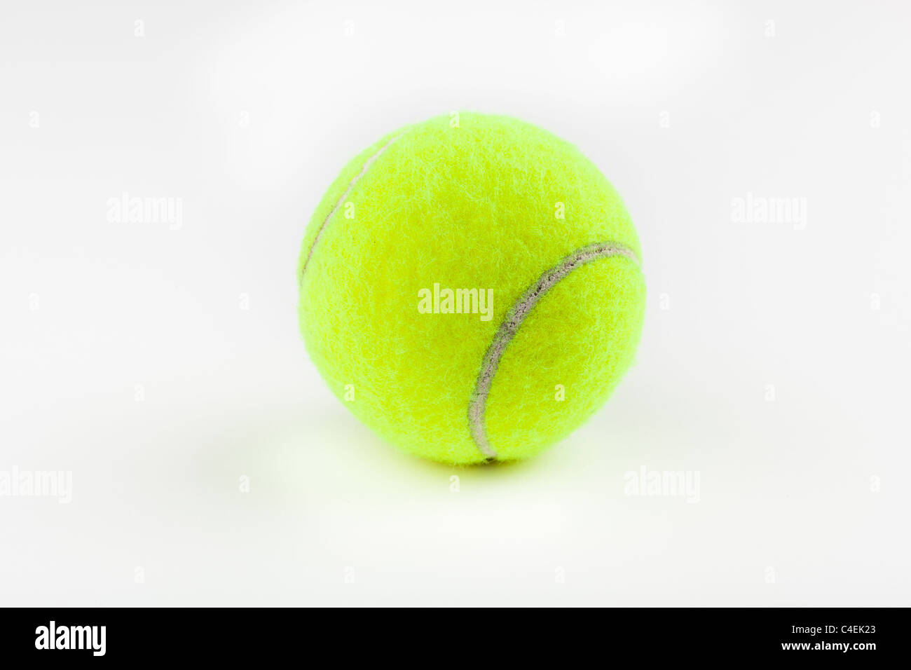A yellow tennis ball against a white background Stock Photo Alamy