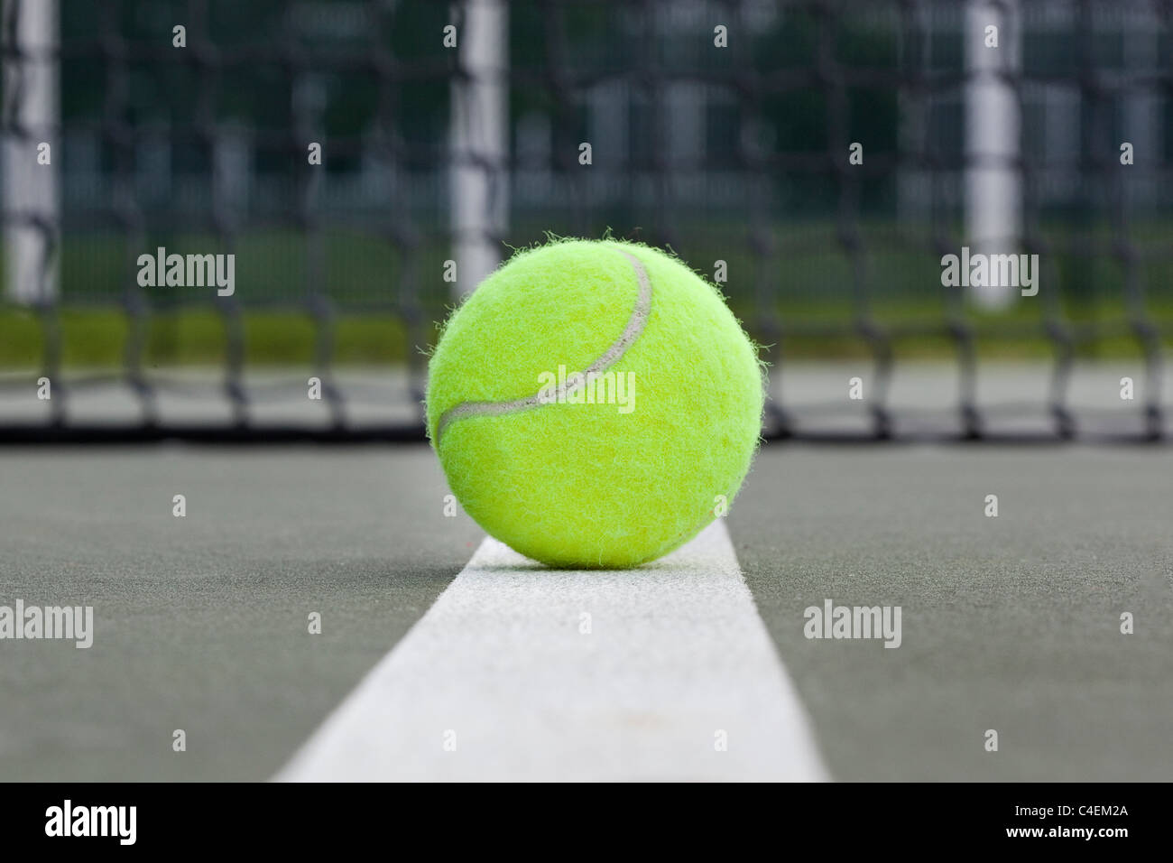 A yellow tennis ball on a tennis court Stock Photo