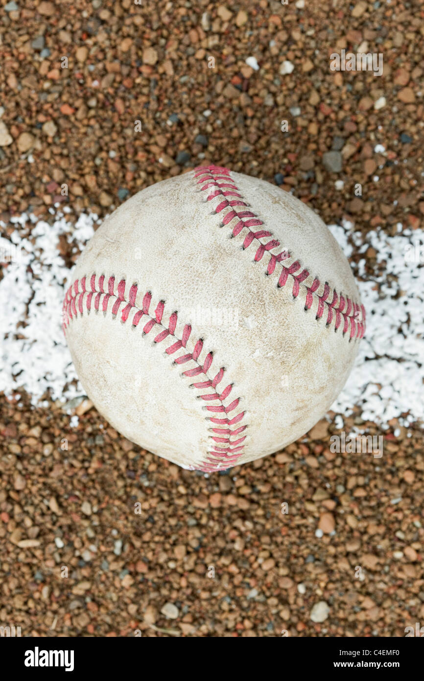 An old worn baseball on a baseball field Stock Photo