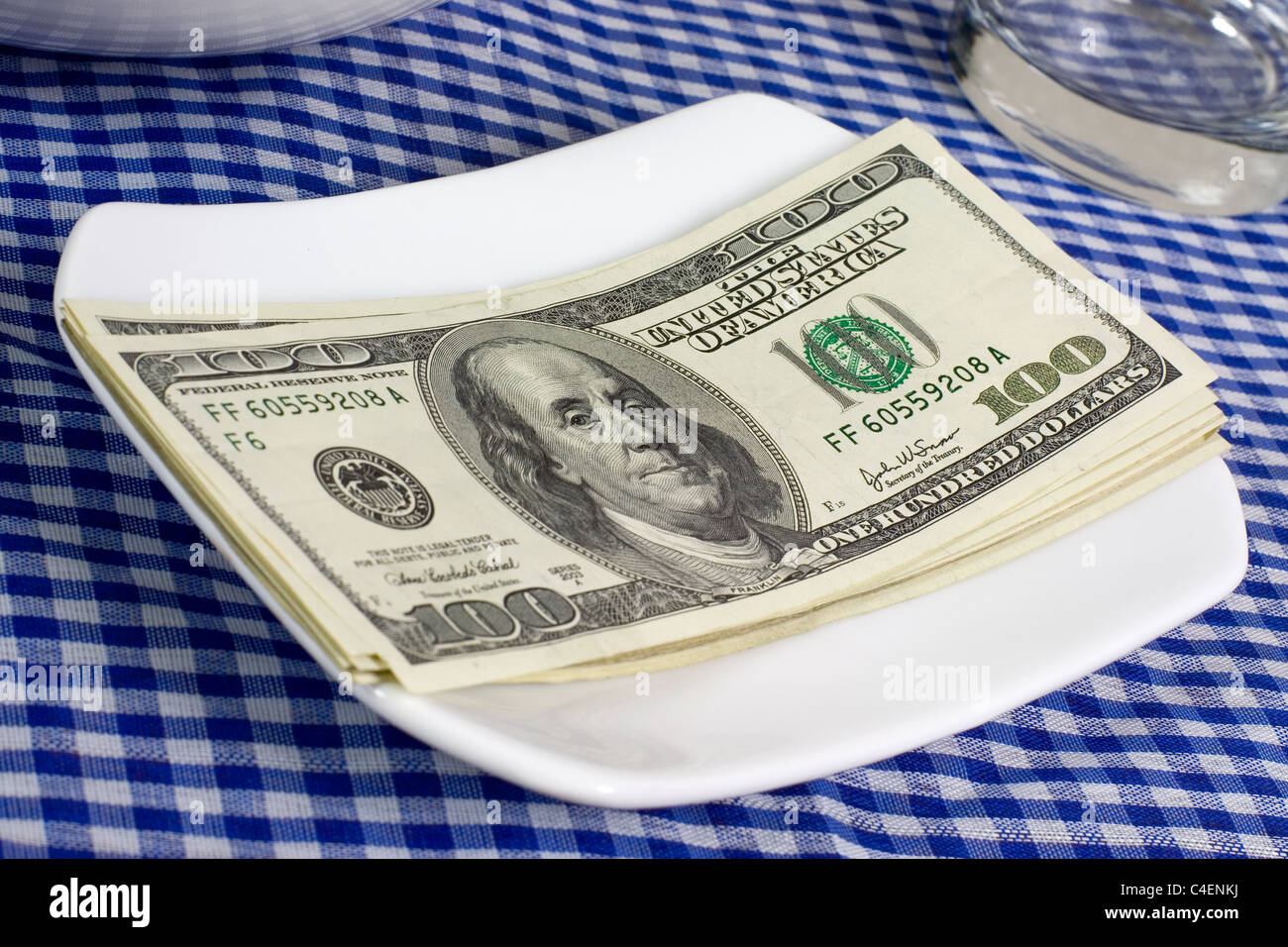 Stack of US currency on a plate on a dining table Stock Photo Alamy