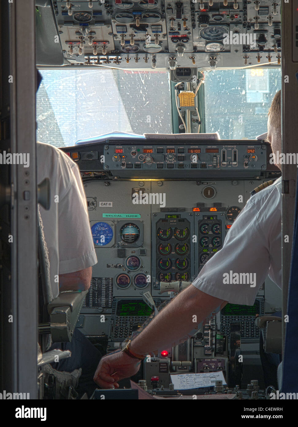 pilots in cockpit of airplane preparing for take off checking the flight instruments Stock Photo