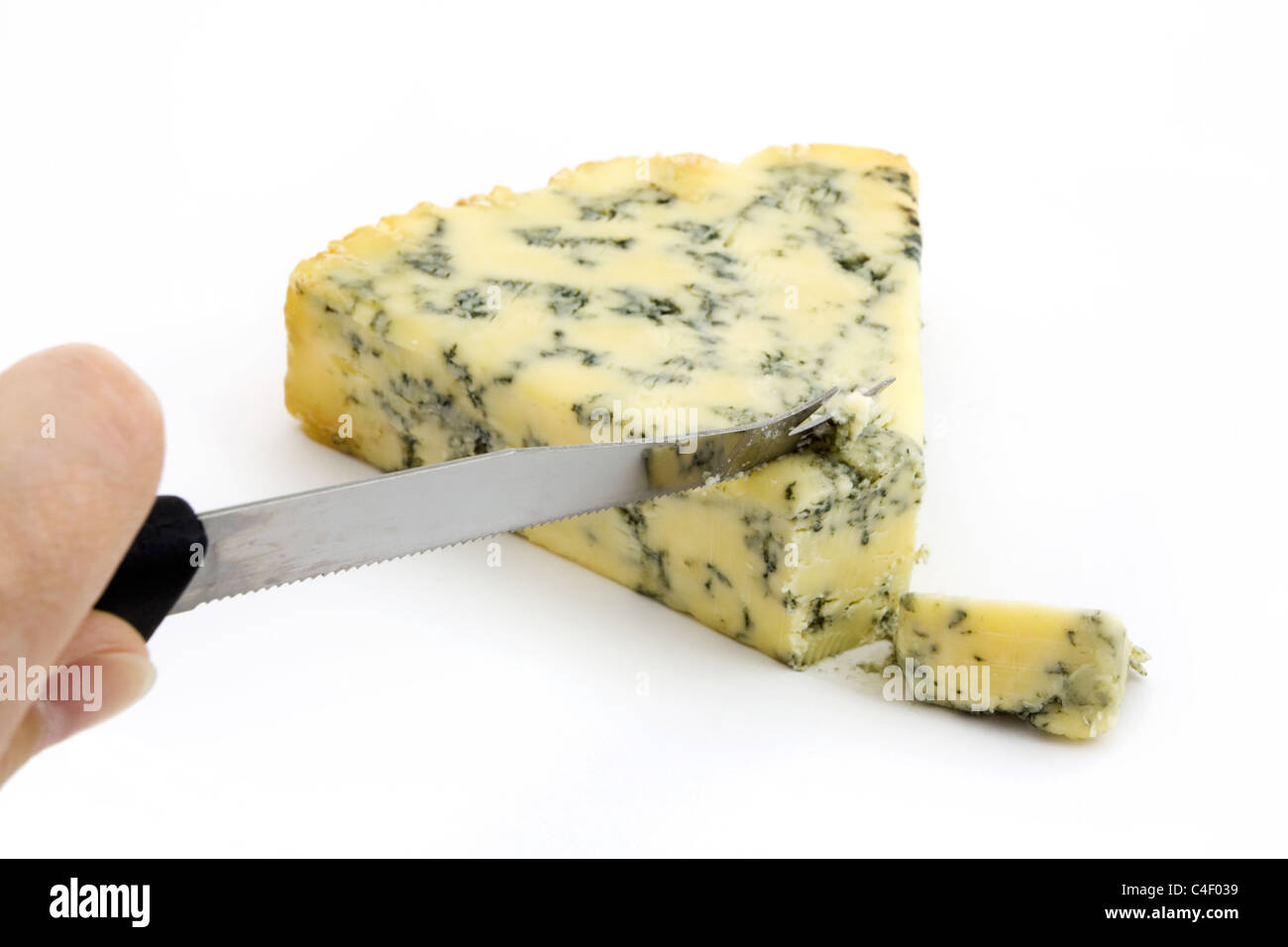 Blue cheese being cut isolated on white Stock Photo