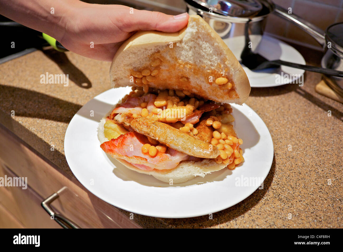 Plate of greasy food. Baked beans bacon sausages chips bread Stock