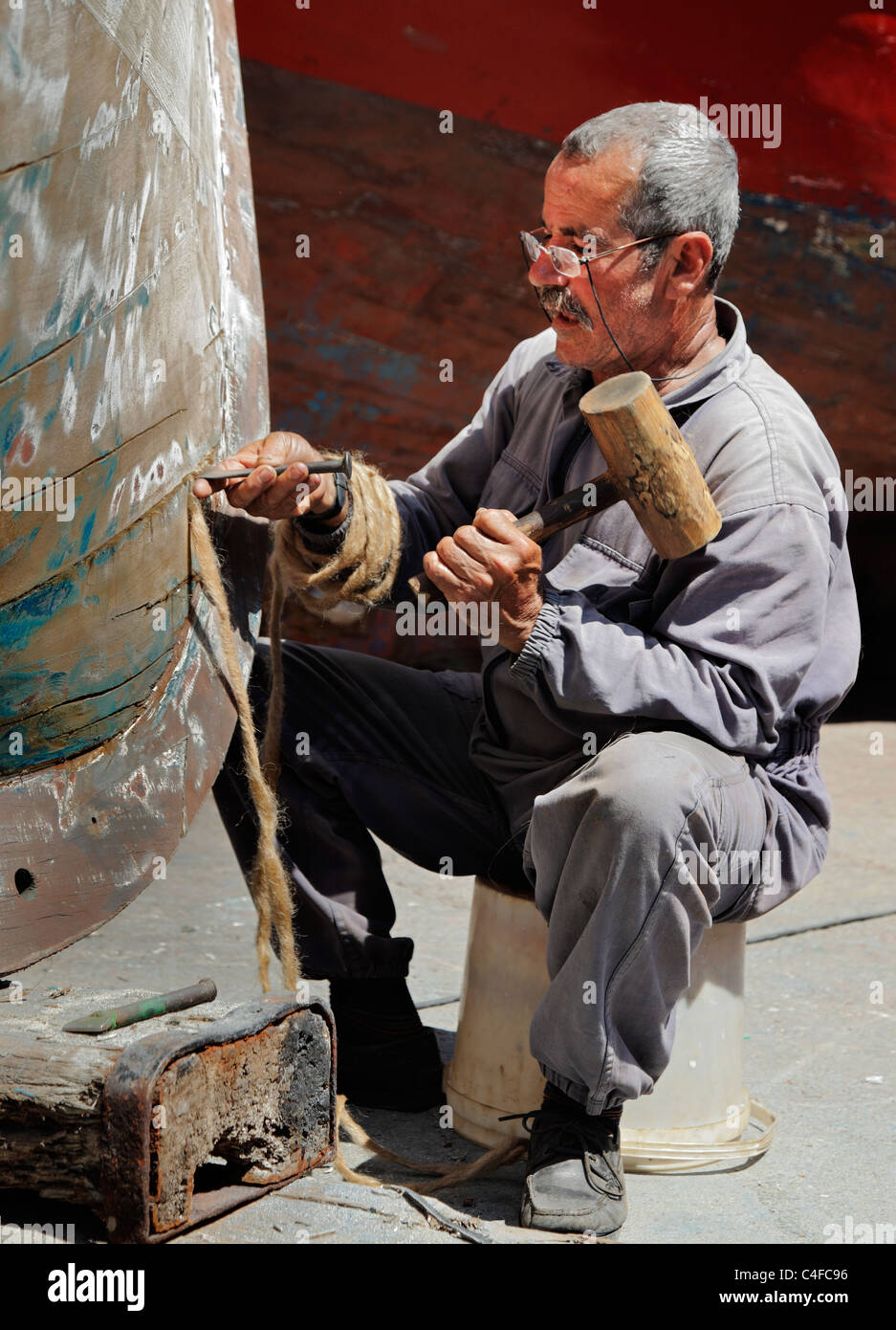 A madeiran fisherman repairing his boat, by Caulking with hemp. Stock Photo