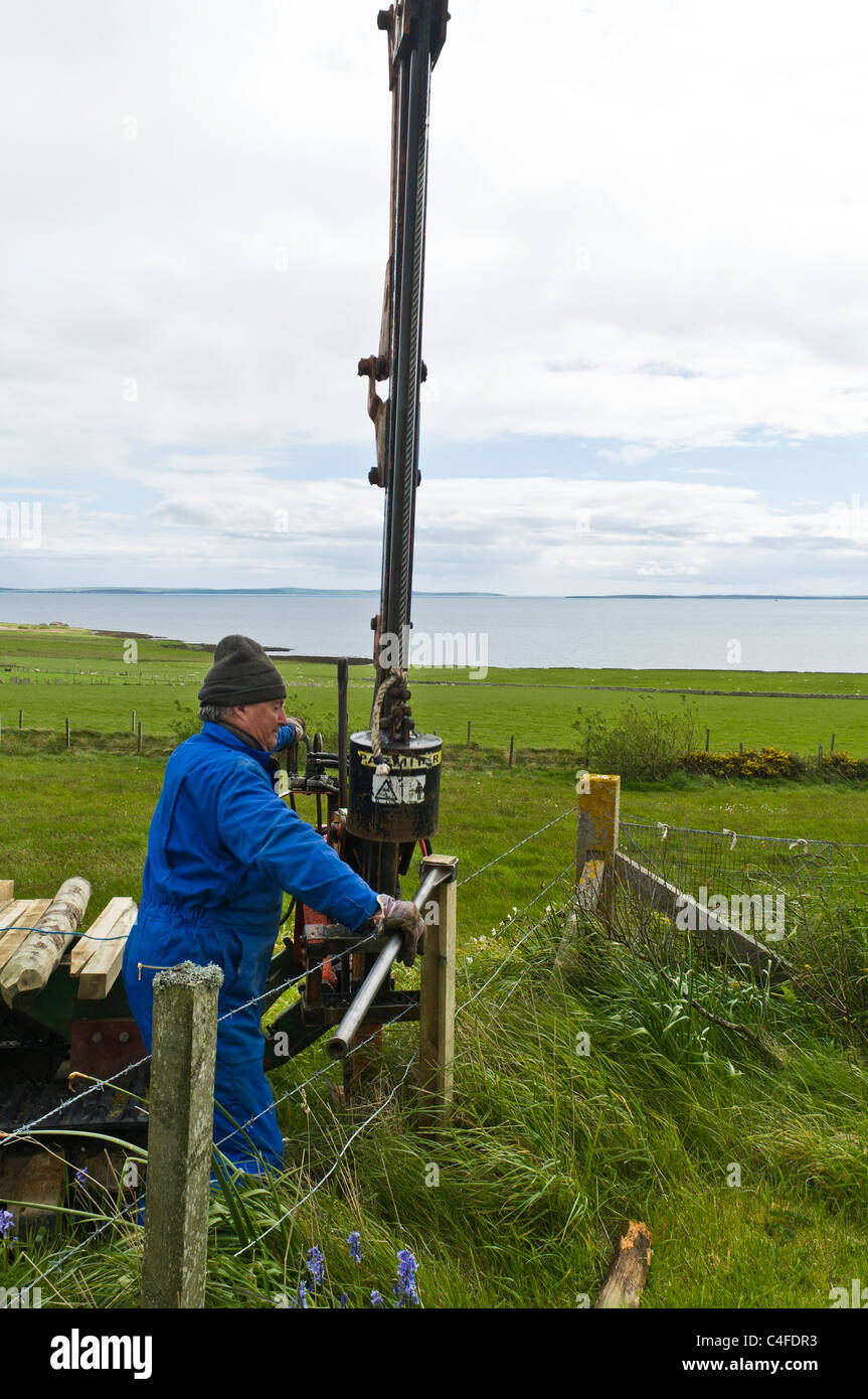 dh  FARMING ORKNEY Low impact tracked post driver hydraulic post drive fencing post fence barbwire field posts contractor machine equipment Stock Photo