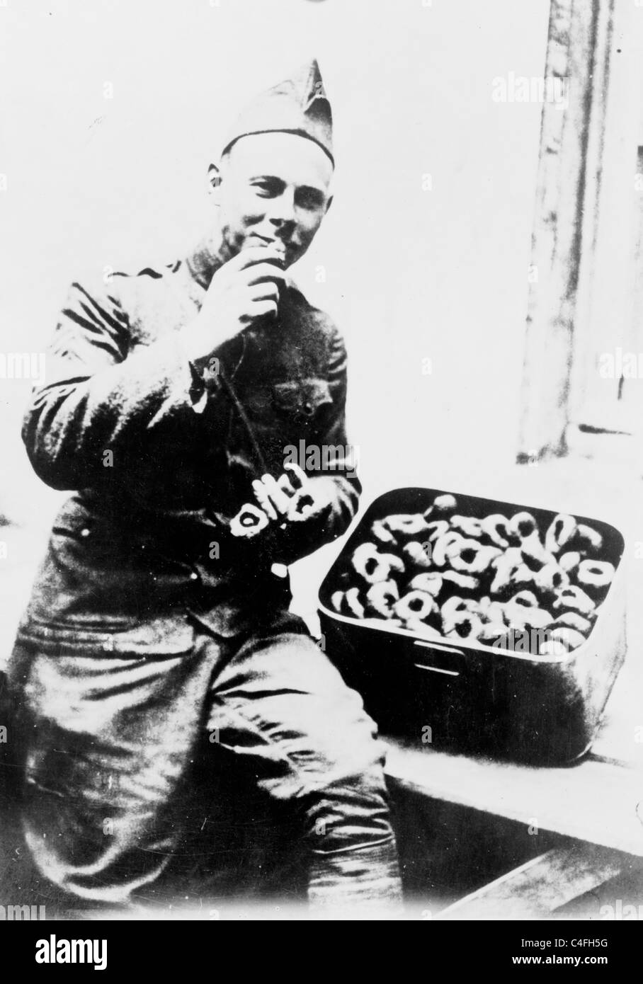 U.S. soldier eating doughnuts (circa 1910 - 1920) Stock Photo