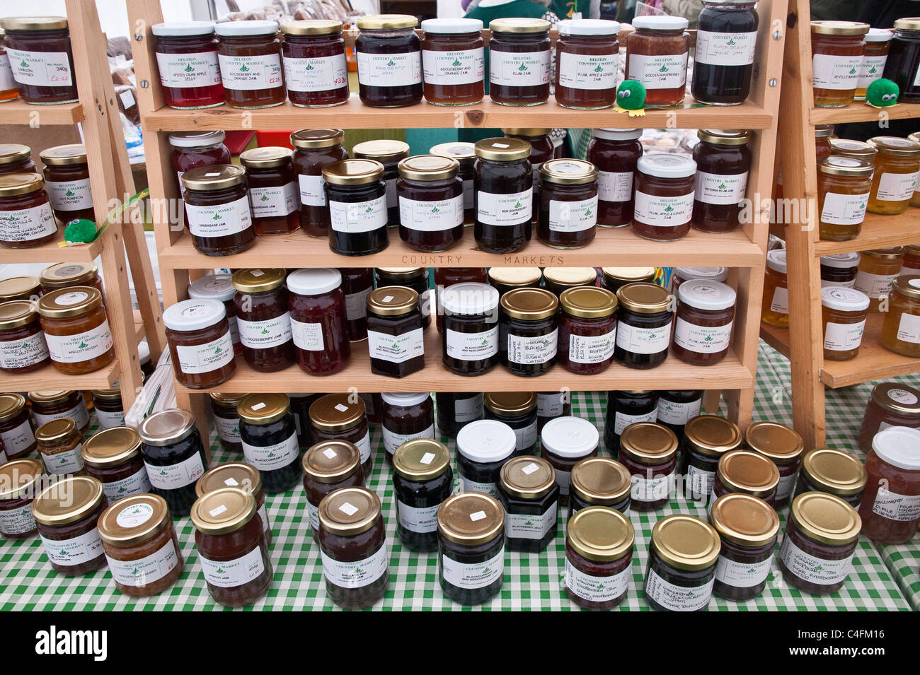 Selection of jars of jam and other preserves for sale at a farmer's market type stall, on a