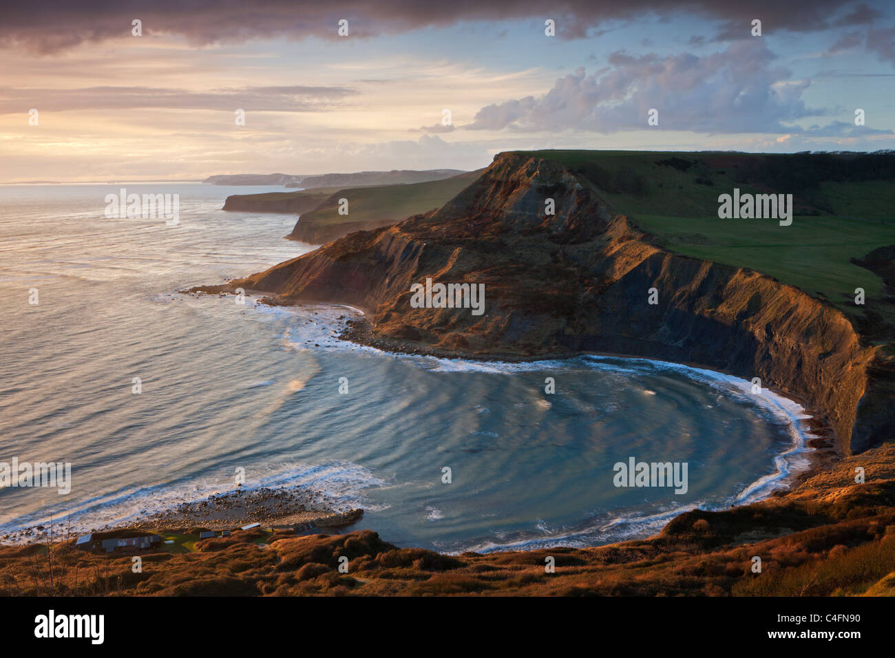 Storm light illuminates Chapmans Pool and Houns Tout cliff, viewed from St Aldhelm's Head, Dorset, England. Stock Photo