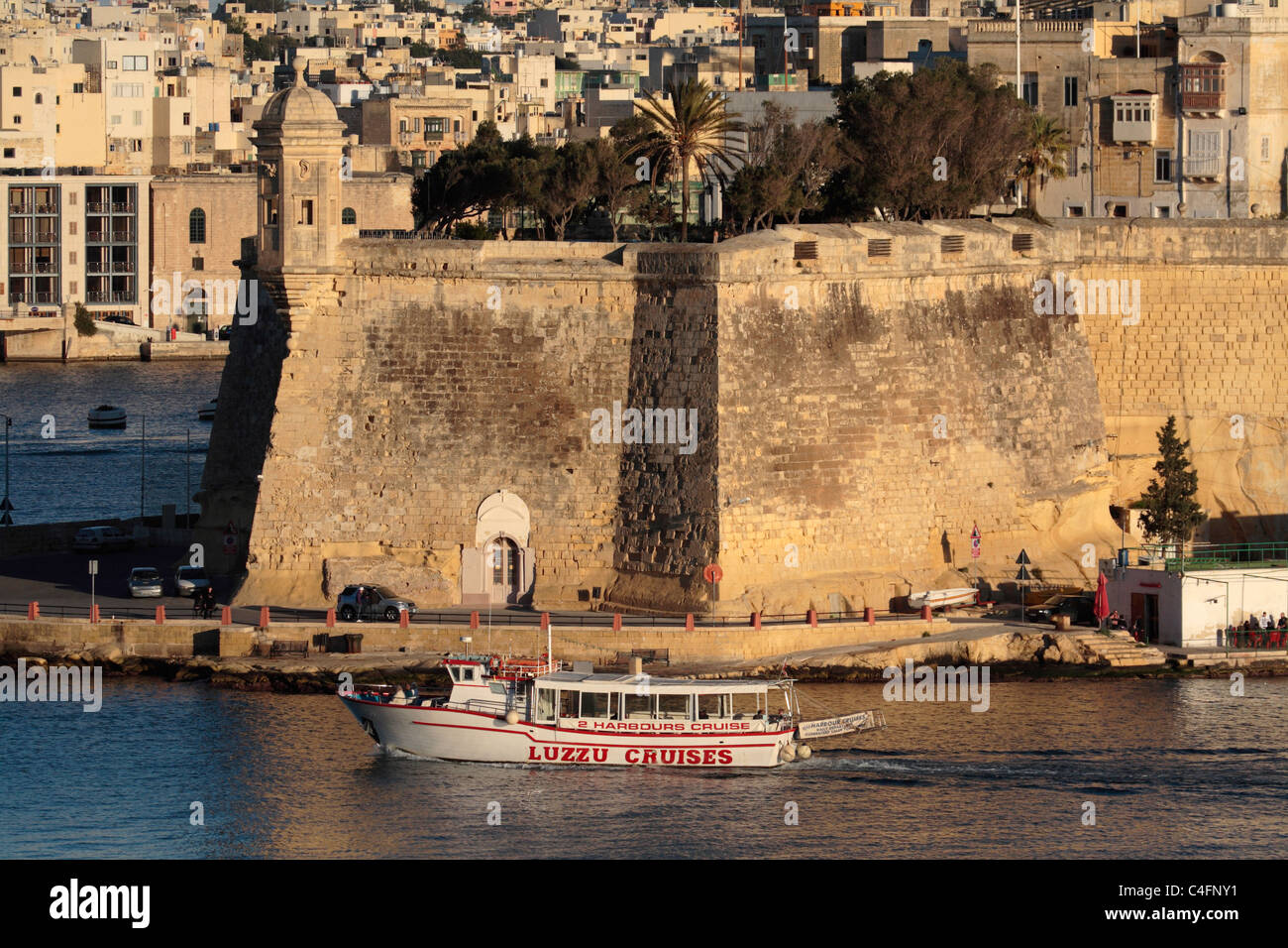 Harbour tour boat rounding Senglea Point in the historic Grand Harbour of Malta. Maltese history. Holiday travel in the Mediterranean. Stock Photo