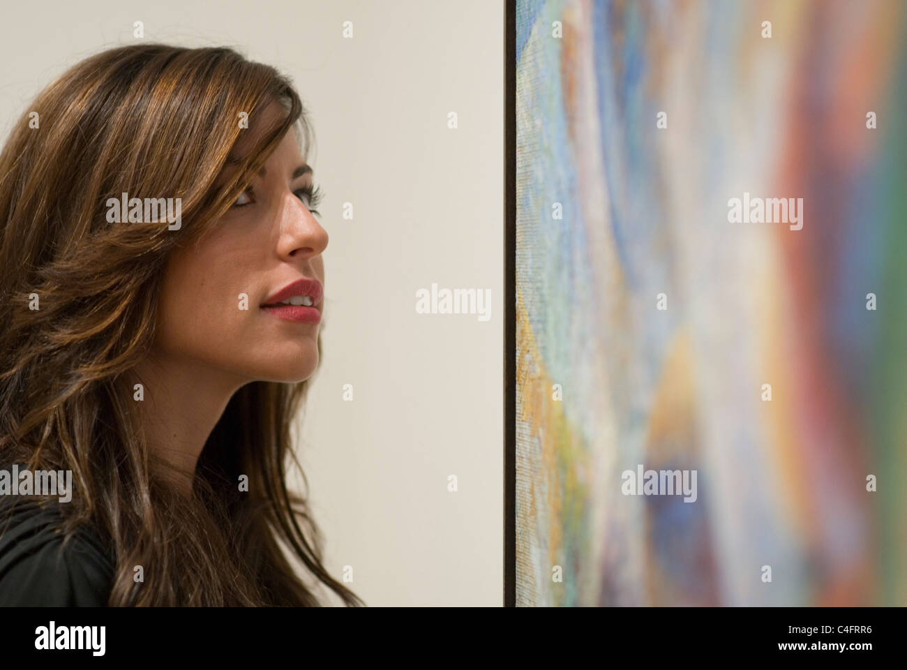 Pretty young woman viewing a large painting in the Museum of Modern Art in New York City. © Craig M. Eisenberg Stock Photo