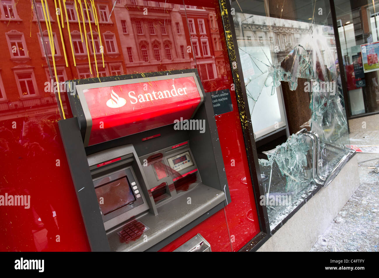 Vandalised bank ATM and smashed window broken by anti capitalists protesters, London, UK Stock Photo