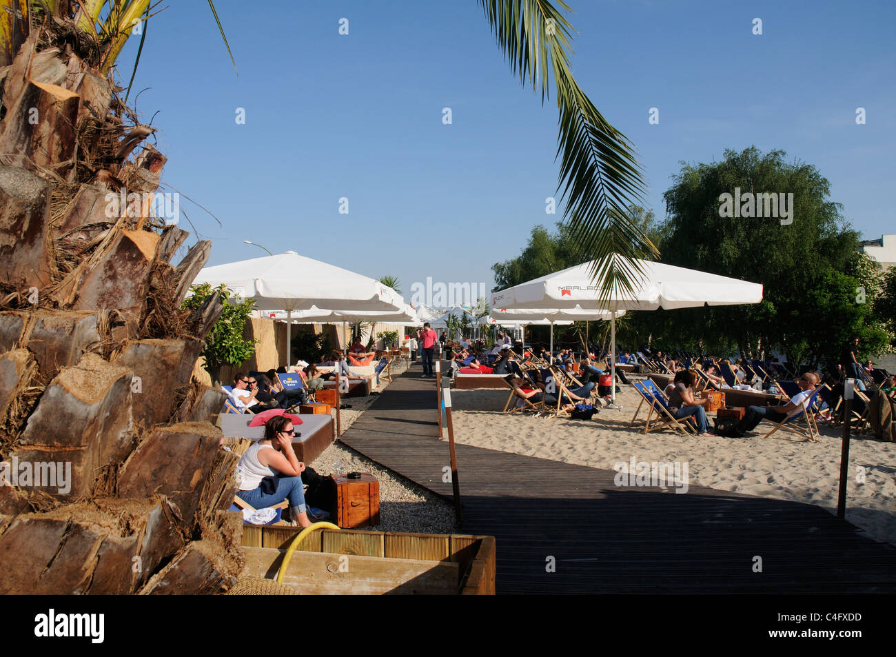 People sat on Eastside Beach, an artificial beach in Berlin, Germany Stock Photo