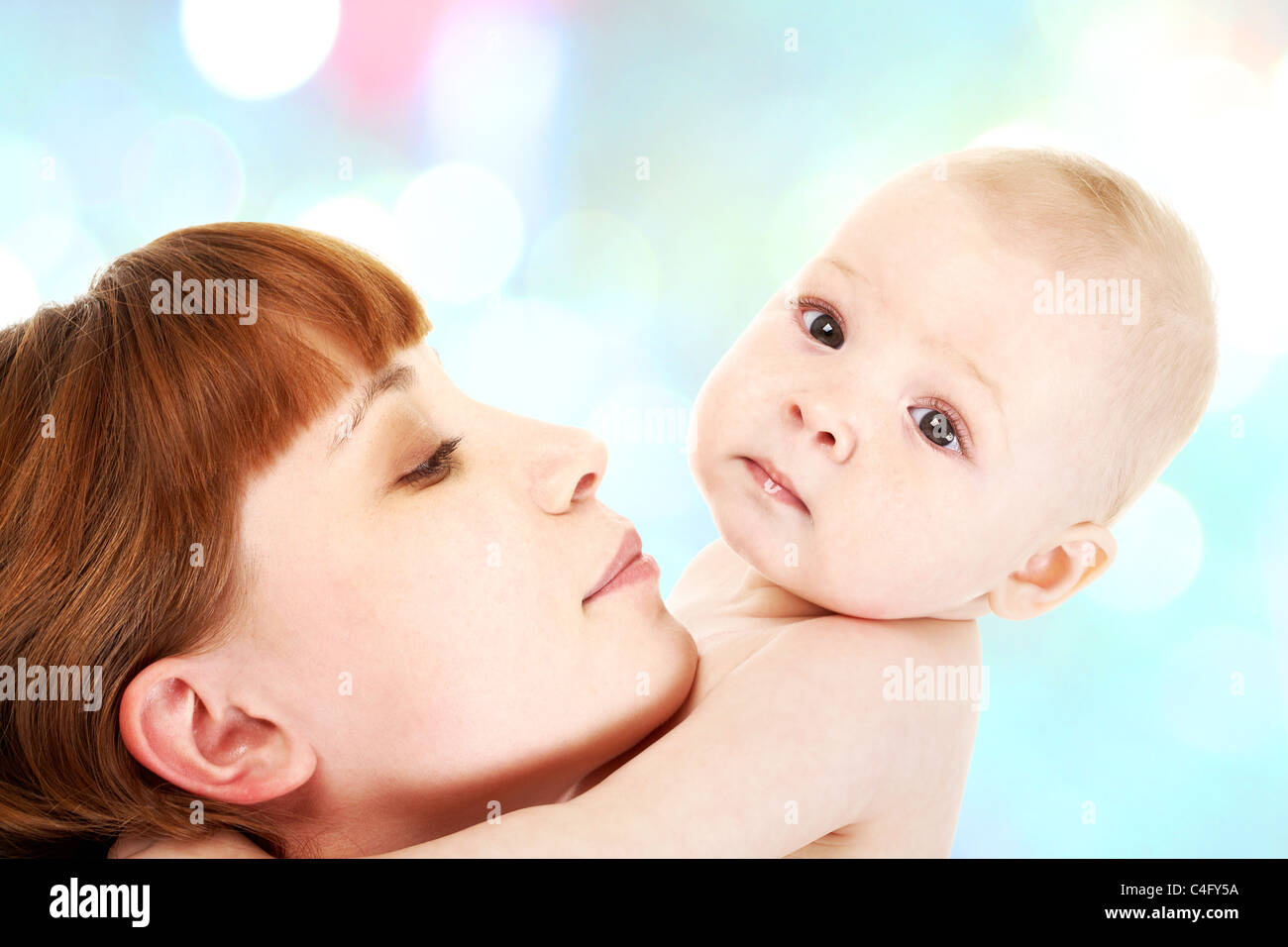 Close-up of careful mummy with her baby on white background Stock Photo