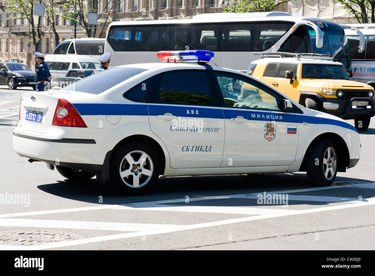 Russia St Petersburg Russian Ford new look police car traffic policeman in background street scene cars traffic trees Stock Photo