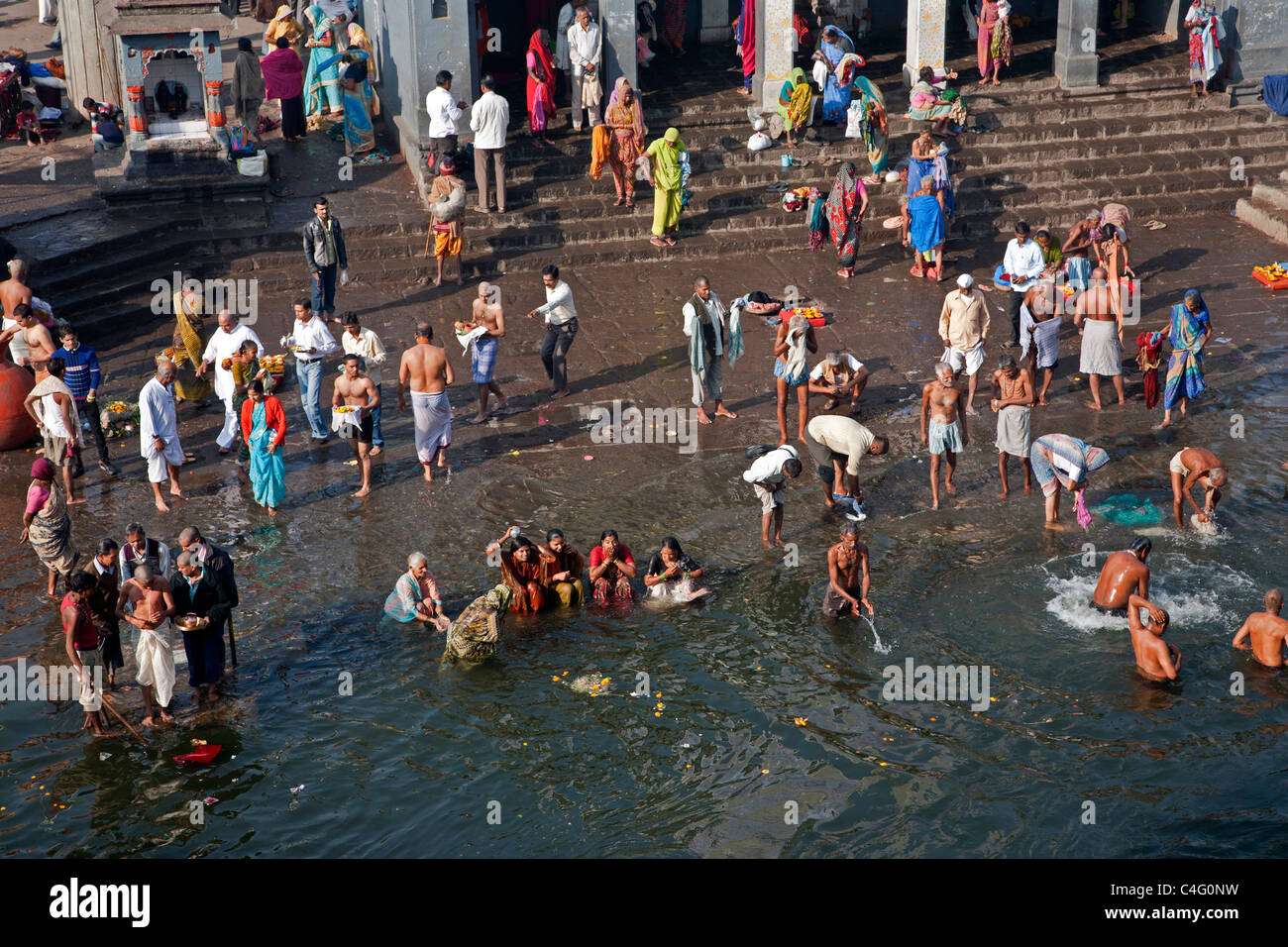 Hindu pilgrims bathing in the sacred waters of the Godavari river. Ram Kund. Nashik. Maharastra. India Stock Photo