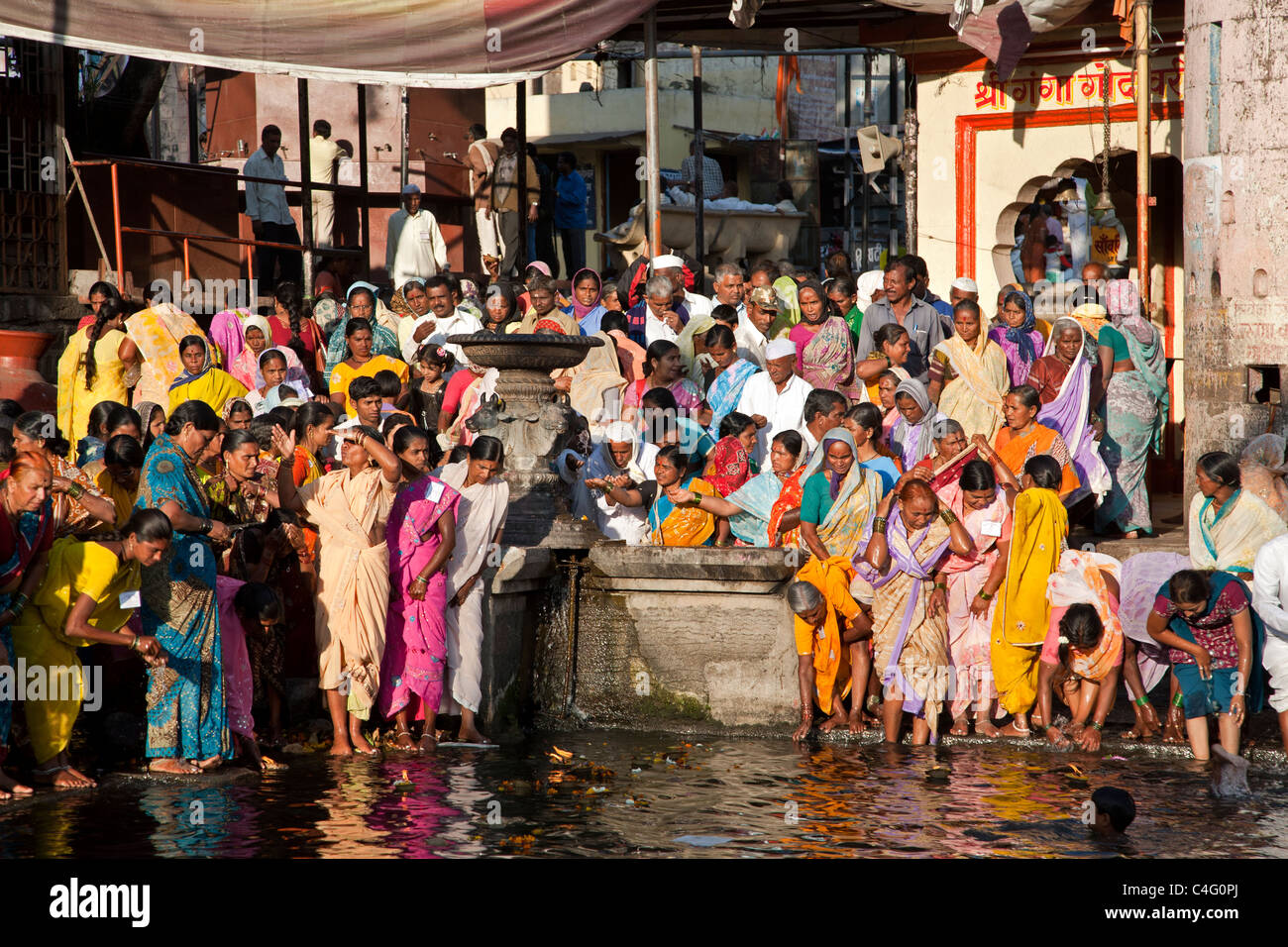 Indian women bathing in the holy waters of the Godavari river. Nasik. India Stock Photo