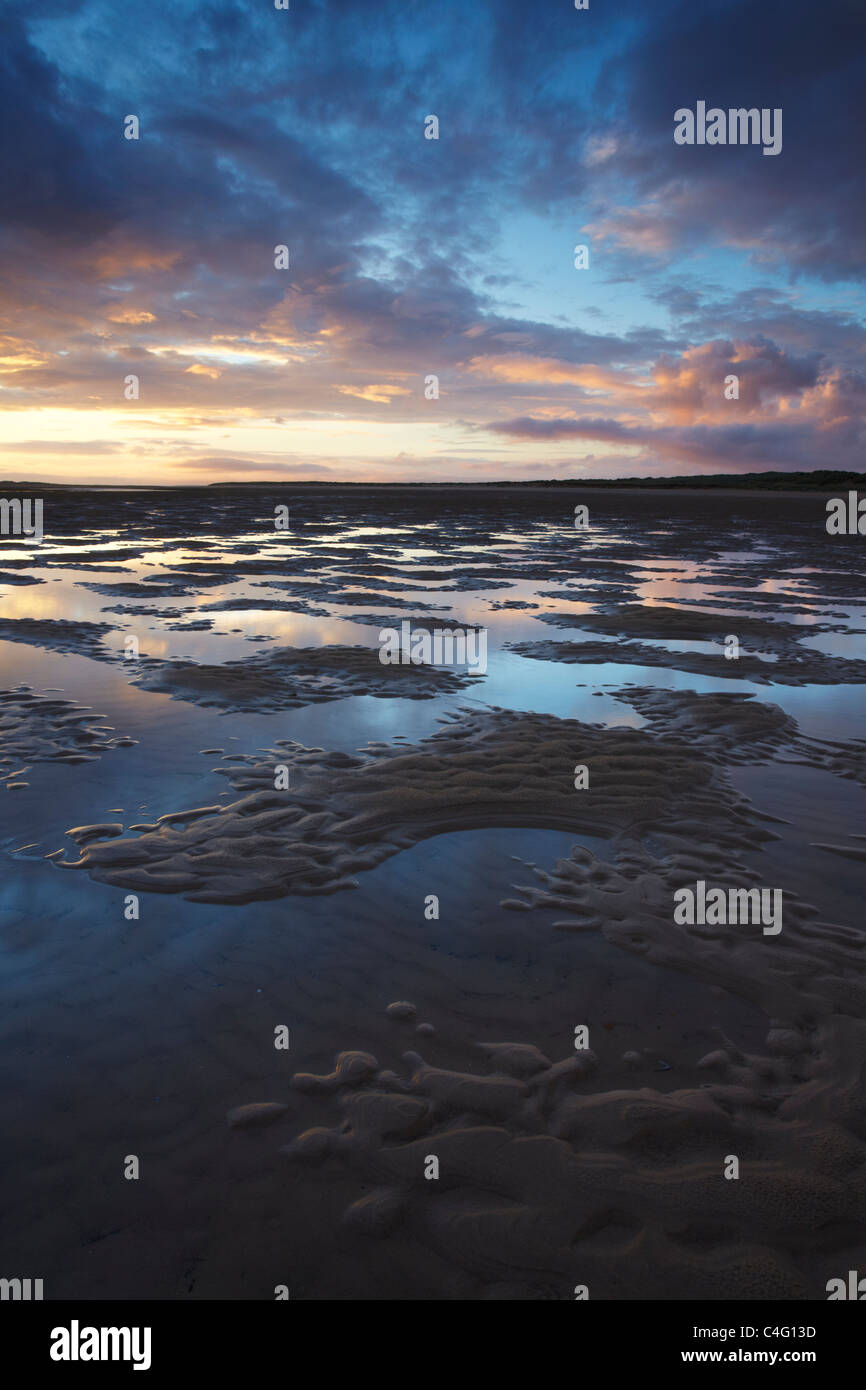 Dawn and low tide at Brancaster Beach at on the North Norfolk Coast in summer Stock Photo