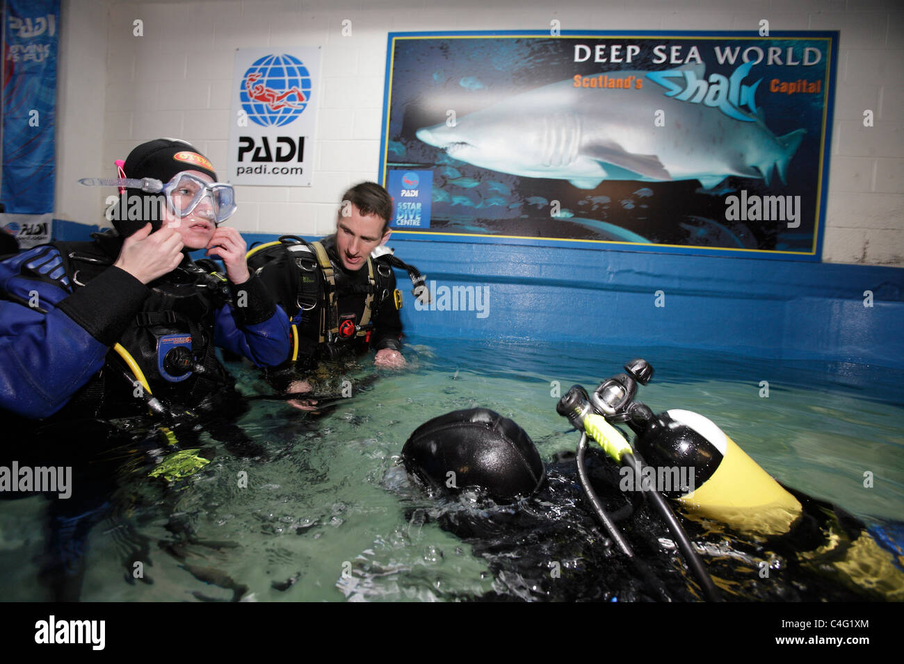 Divers kitup before entering the aquarium at Deep Sea World to dive
