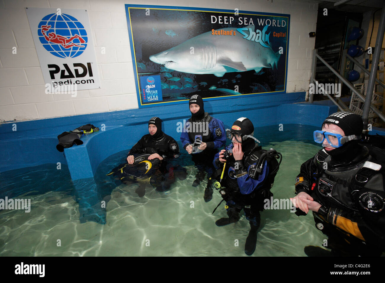 Divers kit-up before entering the aquarium at Deep Sea World to dive with the Sand tiger sharks which are the main attractions Stock Photo