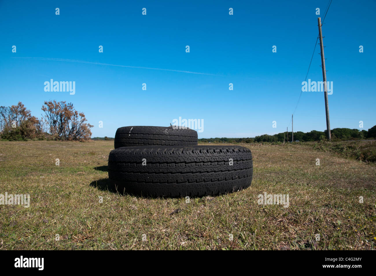 Tyres fly tipped on roadside New Forest Stock Photo
